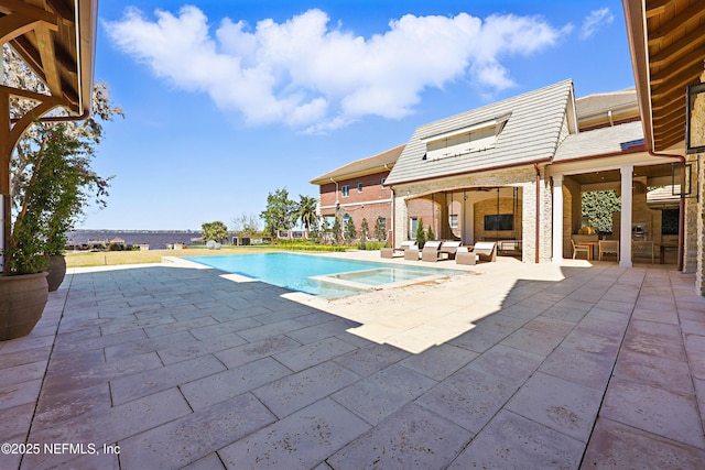 view of swimming pool with a pool with connected hot tub, a patio area, and outdoor lounge area