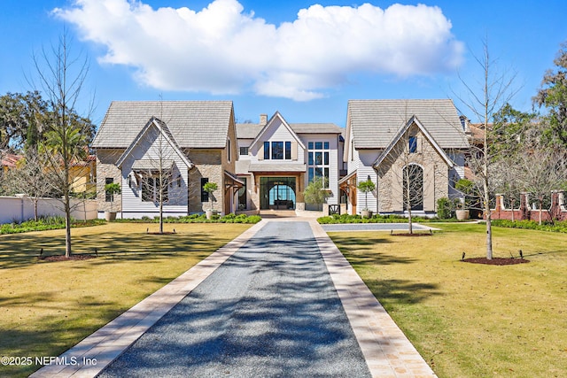 view of front of house with stone siding and a front yard