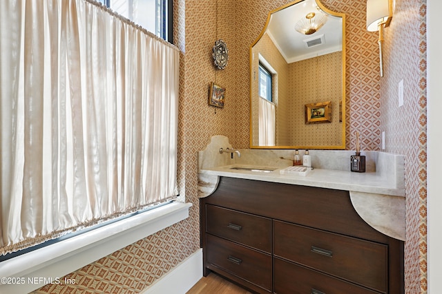 bathroom featuring wallpapered walls, visible vents, crown molding, and vanity