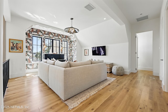 living room with light wood-type flooring, baseboards, and visible vents