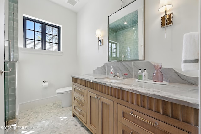 bathroom with baseboards, visible vents, toilet, a tile shower, and vanity