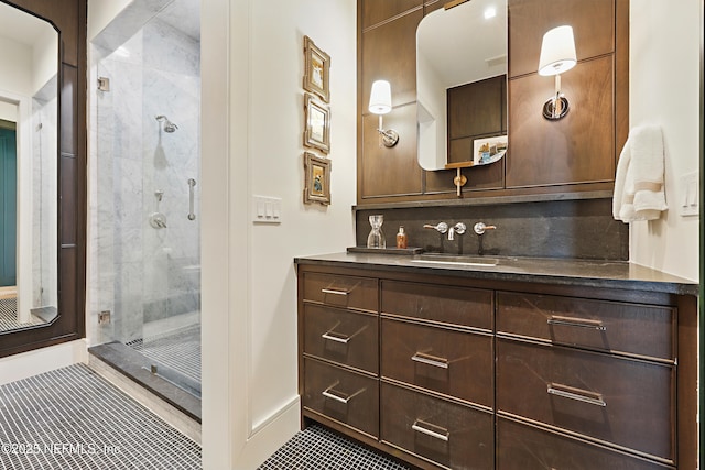 full bathroom featuring baseboards, decorative backsplash, tile patterned flooring, vanity, and a shower stall