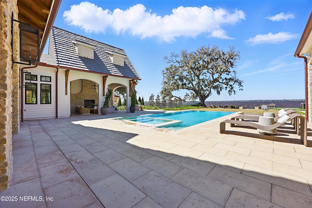 view of swimming pool featuring a pool with connected hot tub and a patio area