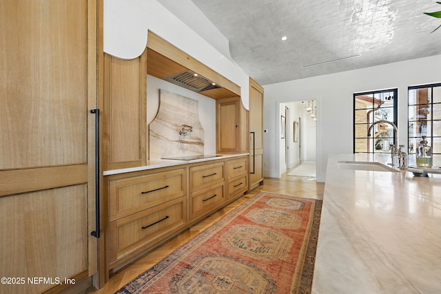 corridor featuring light wood-style flooring and a sink