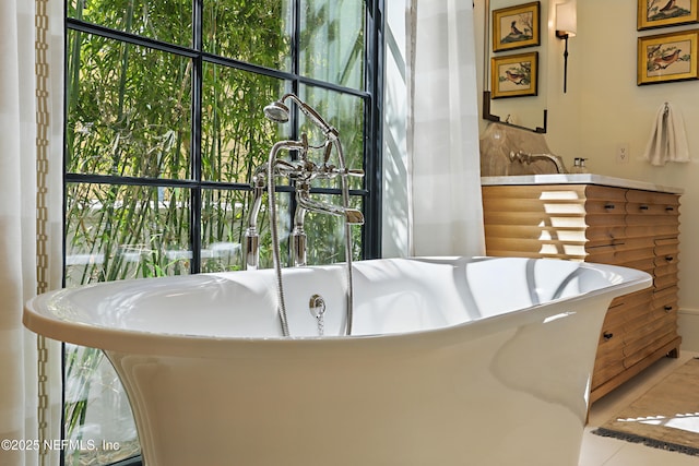 bathroom with a freestanding tub and tile patterned floors