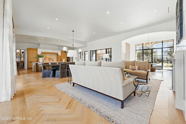 living room featuring a chandelier, arched walkways, and recessed lighting