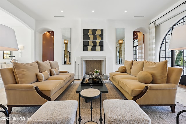 living area with a fireplace, arched walkways, and recessed lighting