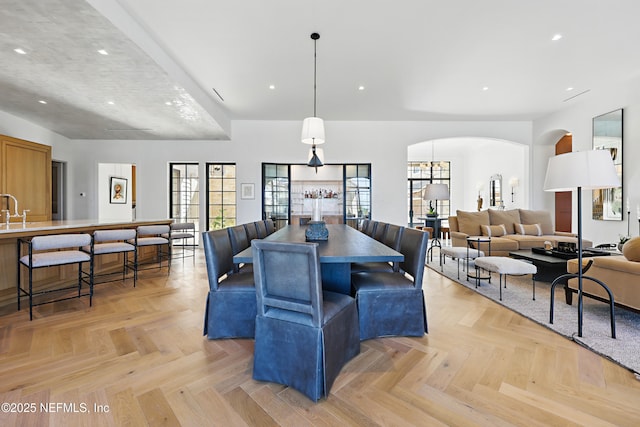 dining room featuring arched walkways and recessed lighting