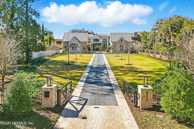 view of home's community featuring a gate, fence, and a lawn