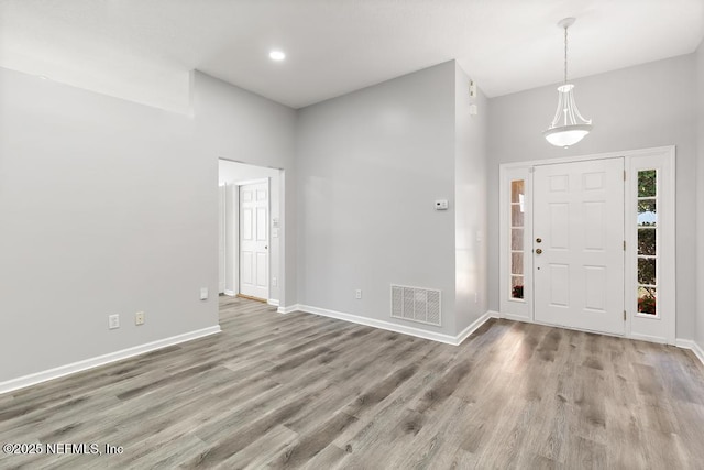 entryway featuring visible vents, baseboards, and wood finished floors