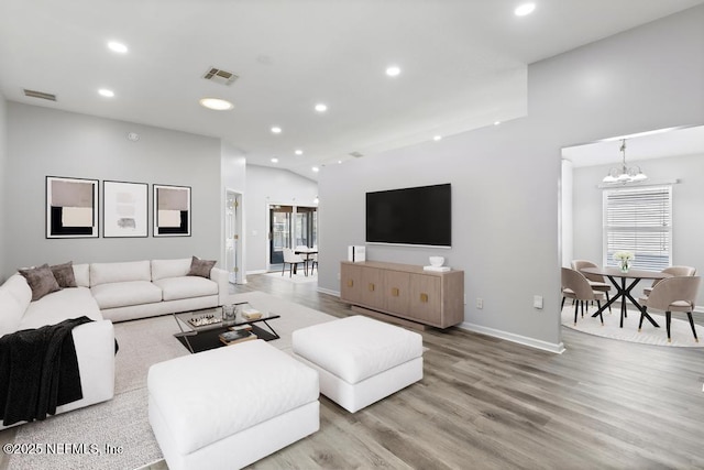 living area featuring recessed lighting, wood finished floors, visible vents, and an inviting chandelier