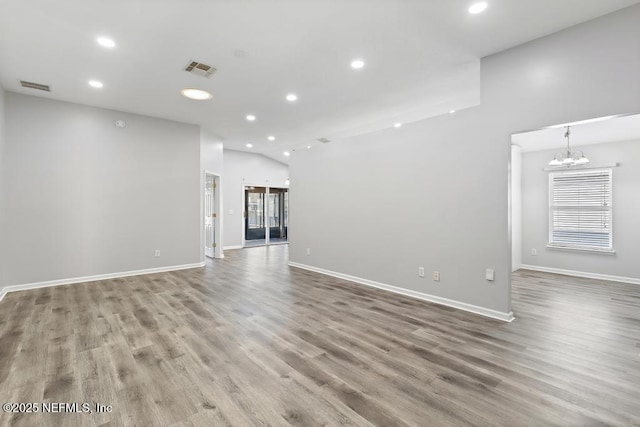 unfurnished living room with a notable chandelier, visible vents, wood finished floors, and recessed lighting