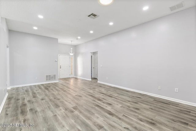 empty room featuring visible vents, wood finished floors, and recessed lighting