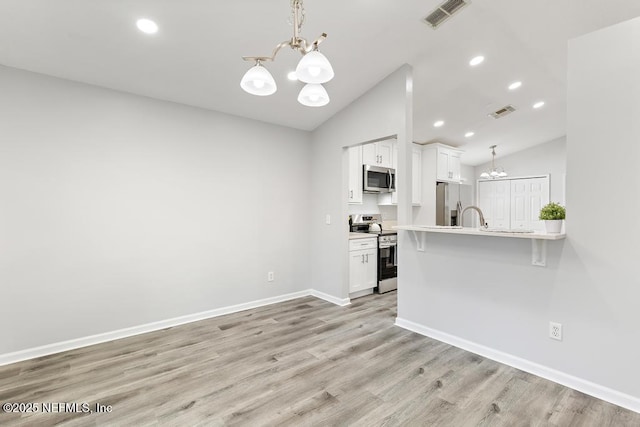 kitchen featuring visible vents, appliances with stainless steel finishes, white cabinets, and a notable chandelier