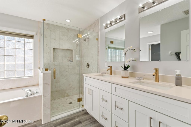 full bathroom featuring visible vents, a sink, a bath, and a shower stall