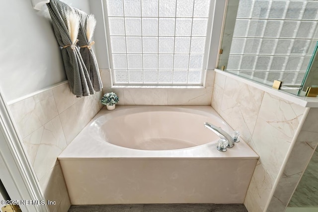 full bathroom featuring a garden tub and tile walls