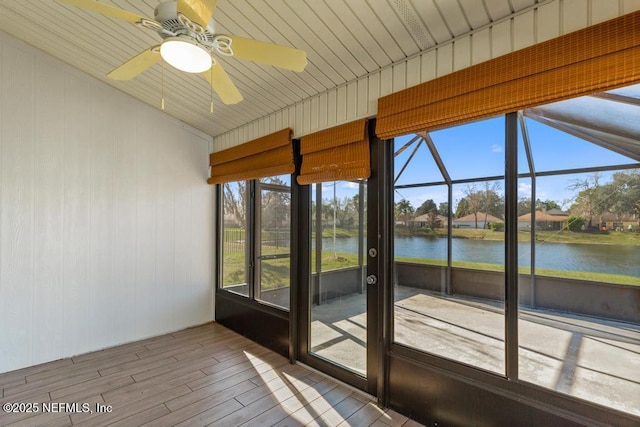 unfurnished sunroom with a water view and ceiling fan