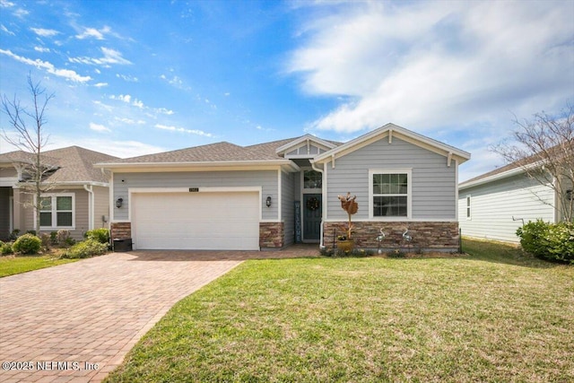 view of front facade featuring a garage, a front yard, decorative driveway, and stone siding