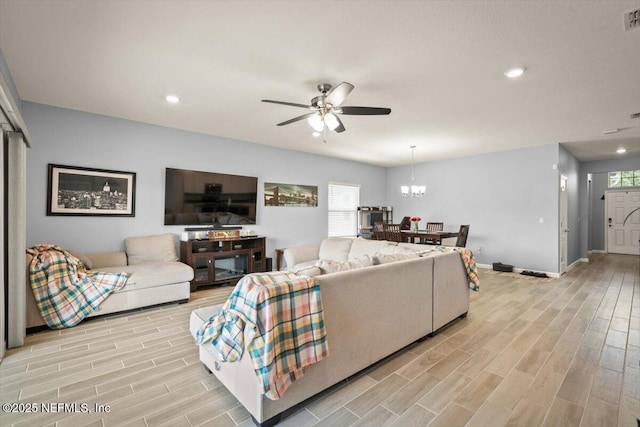 living room with recessed lighting, ceiling fan with notable chandelier, visible vents, baseboards, and wood tiled floor