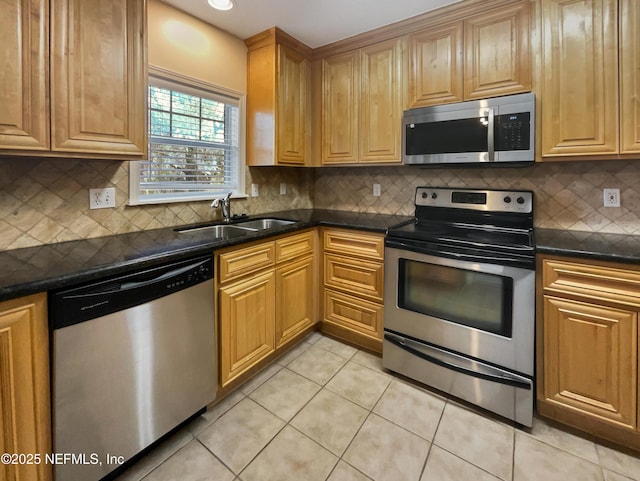 kitchen with stainless steel appliances, a sink, decorative backsplash, and light tile patterned floors