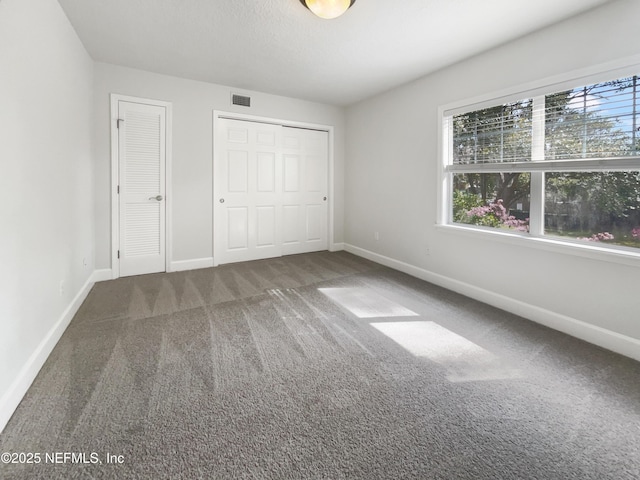 unfurnished bedroom featuring baseboards, visible vents, and carpet flooring