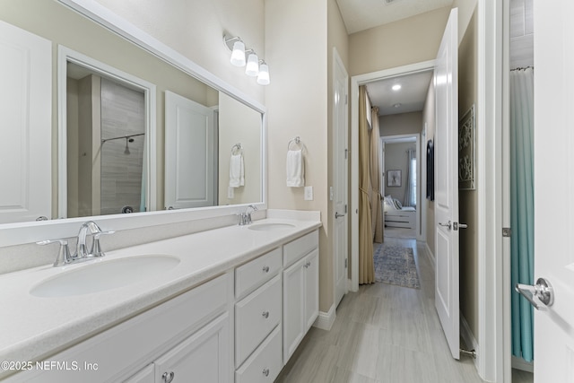 full bath featuring a sink, connected bathroom, and double vanity