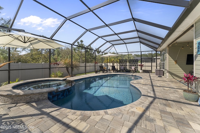 view of swimming pool featuring glass enclosure, fence, a pool with connected hot tub, and a patio area