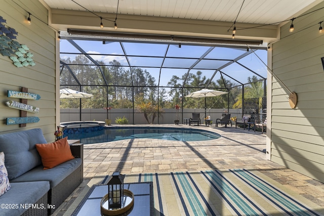 view of swimming pool featuring a pool with connected hot tub, fence, glass enclosure, outdoor lounge area, and a patio