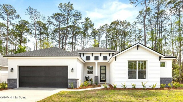19 Essex Ln, Palm Coast, FL 32164 - view of front facade featuring a front yard, concrete driveway, and an attached garage