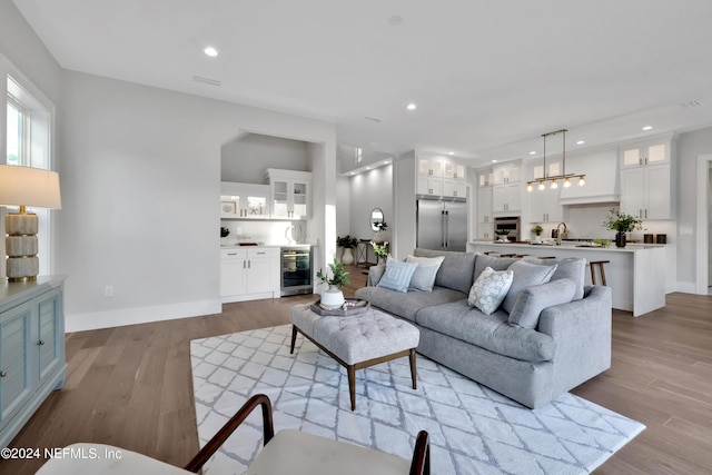 living room featuring recessed lighting, beverage cooler, and light wood finished floors