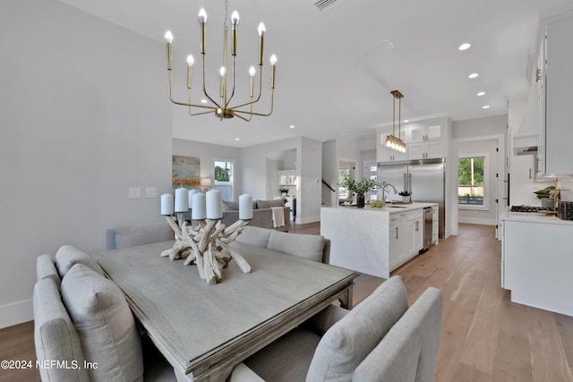 dining area featuring baseboards, recessed lighting, light wood-type flooring, and a notable chandelier