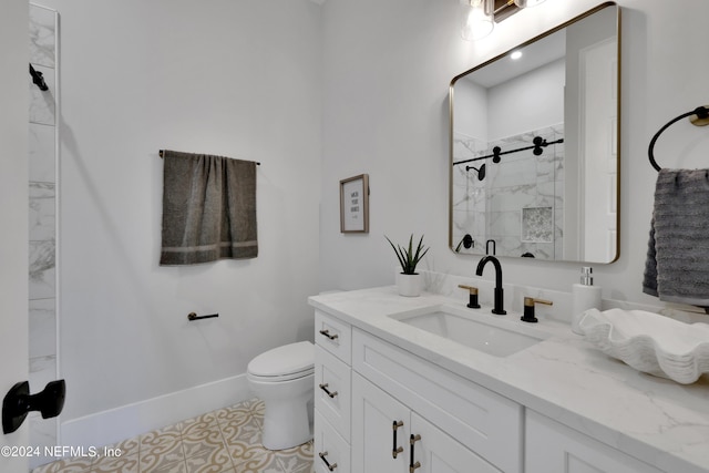 bathroom with toilet, a stall shower, baseboards, and vanity