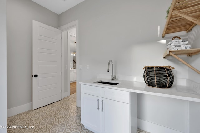 kitchen with white cabinets, a sink, baseboards, and open shelves