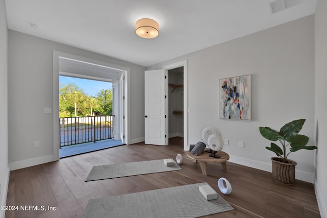 exercise area featuring baseboards, visible vents, and wood finished floors