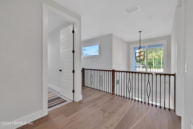 interior space featuring a wealth of natural light, visible vents, a notable chandelier, and wood finished floors