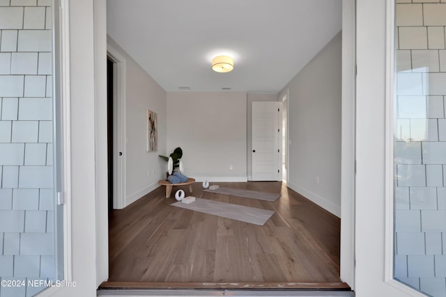 foyer with wood finished floors, visible vents, and baseboards