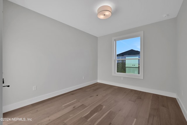 spare room featuring wood finished floors and baseboards