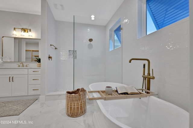 full bath with marble finish floor, a freestanding bath, vanity, and a walk in shower