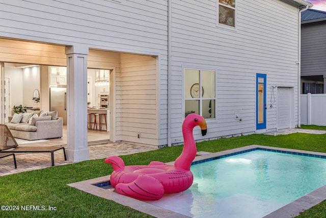 view of pool featuring a lawn, an outdoor hangout area, a fenced in pool, and a patio