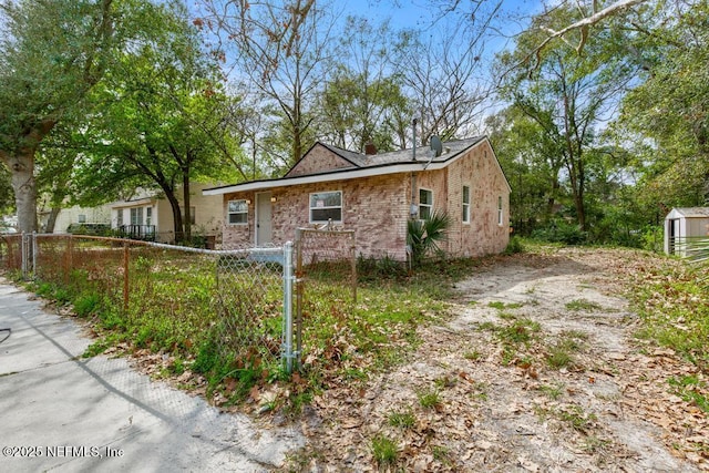 view of property exterior with a fenced front yard and brick siding