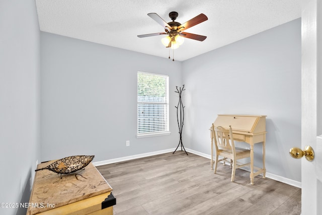 misc room with a textured ceiling, wood finished floors, and baseboards