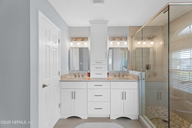 bathroom with a healthy amount of sunlight, a sink, and a shower stall