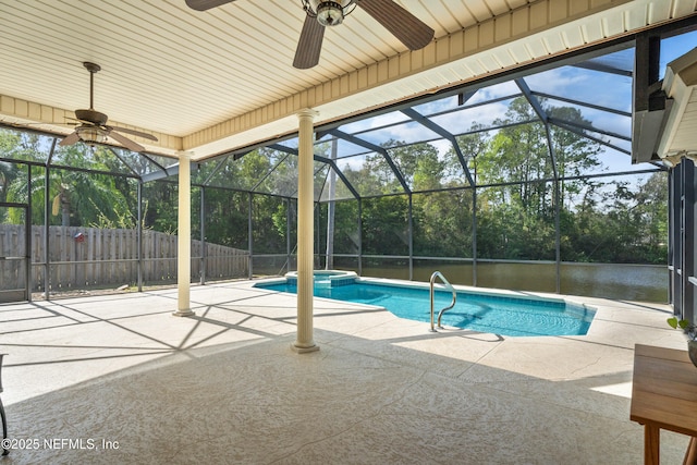 view of swimming pool with glass enclosure, a patio area, a pool with connected hot tub, and fence