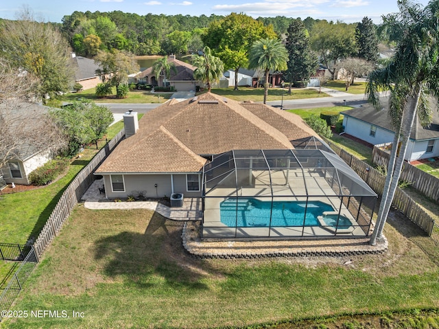 view of swimming pool featuring a fenced backyard, a lanai, a yard, a patio area, and a pool with connected hot tub