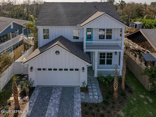 view of front of home featuring decorative driveway, board and batten siding, and a shingled roof