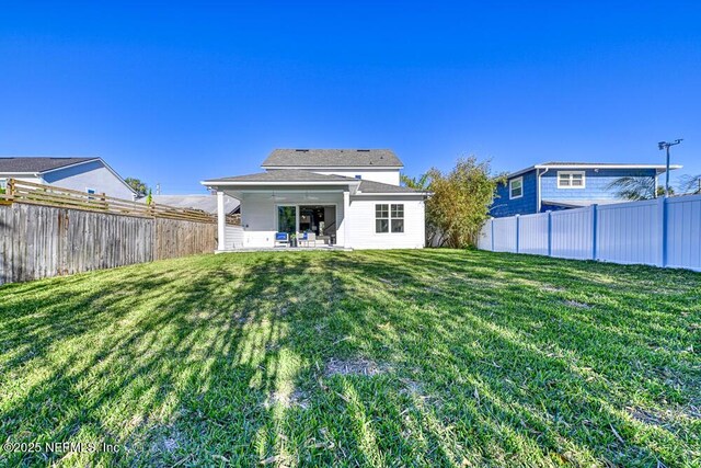 back of property featuring a patio area, a yard, and a fenced backyard