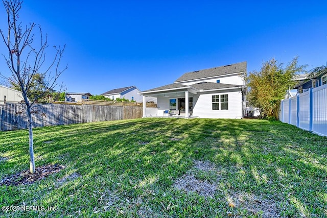 back of property featuring a patio, a yard, and a fenced backyard