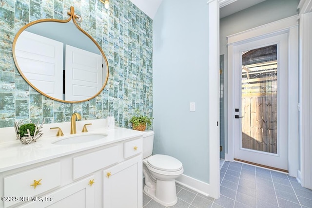 bathroom featuring tile patterned floors, baseboards, toilet, and vanity