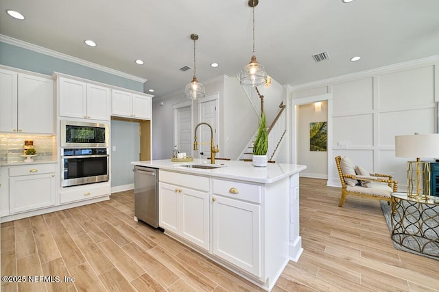 kitchen featuring visible vents, a sink, decorative backsplash, white cabinets, and appliances with stainless steel finishes