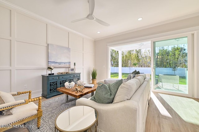 living room featuring recessed lighting, ceiling fan, crown molding, and a decorative wall